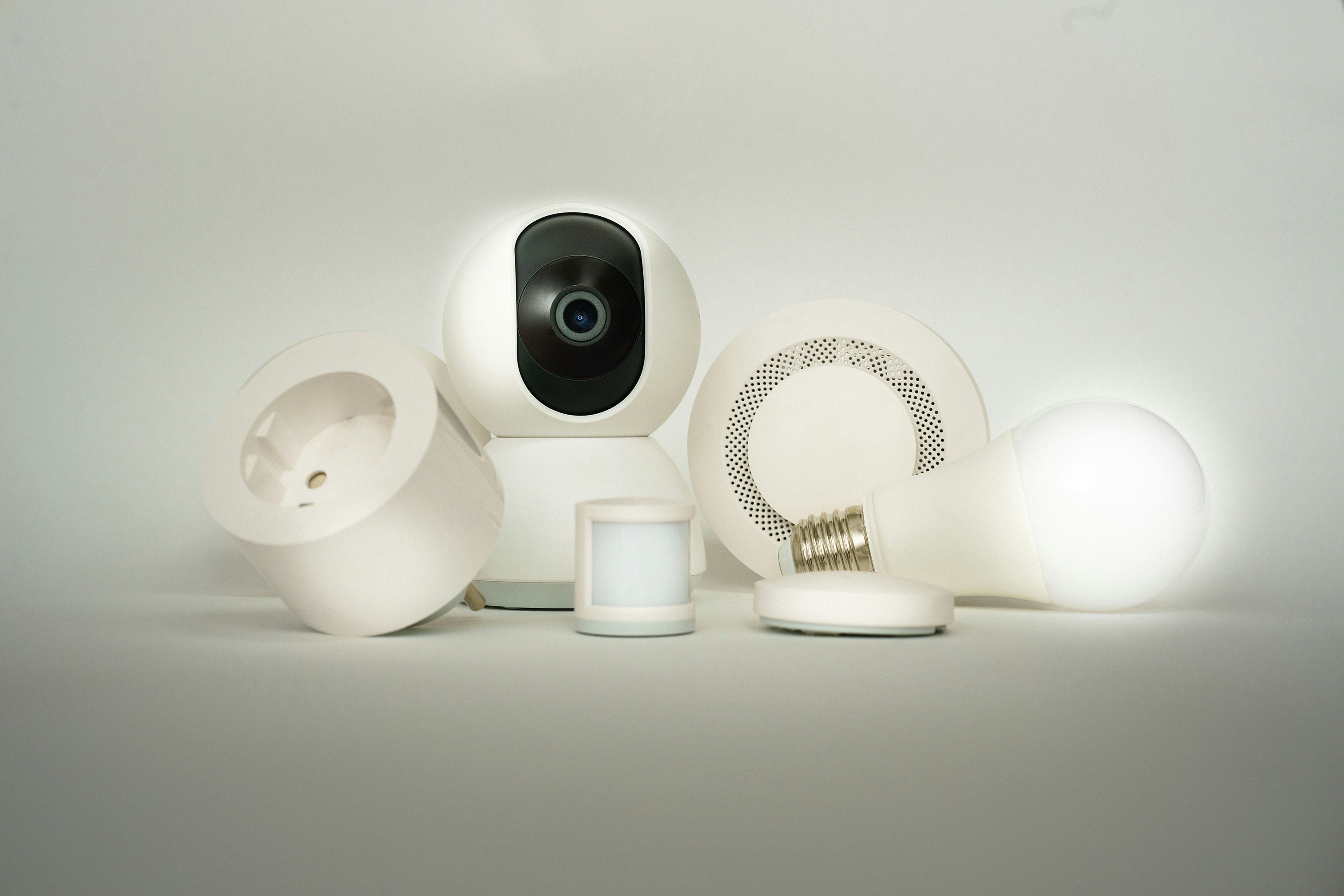 Collection of smart home security devices including a camera, sensors, and a smart bulb